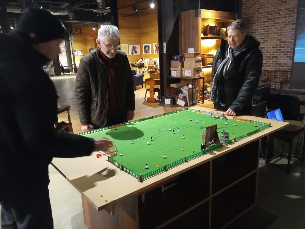 Members enjoying a game of table football at a community venue
